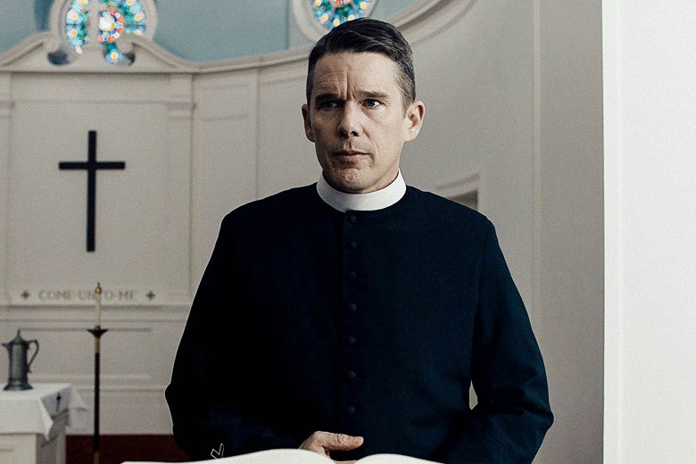 Ethan Hawke, dressed as a reverent at the front of a church, in the film First Reformed.