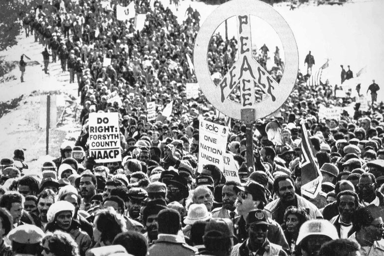Hundreds of civil rights marchers carry signs