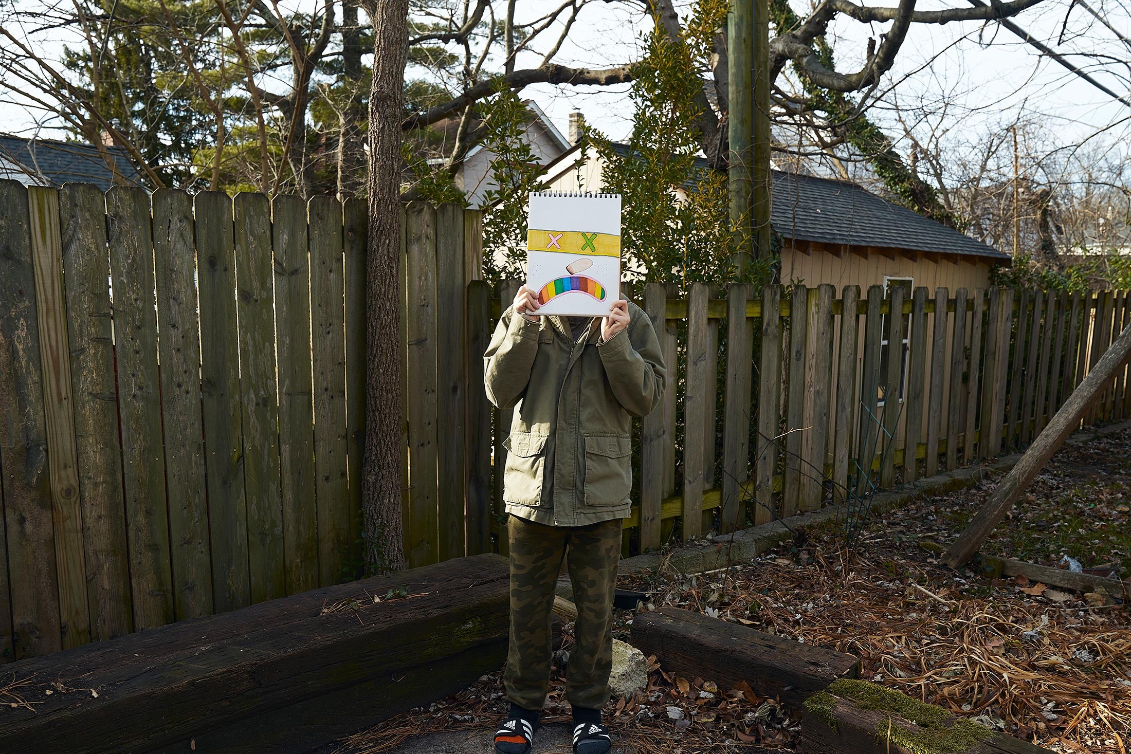 Casey, holding a drawing up obscuring his face, sixth grade.