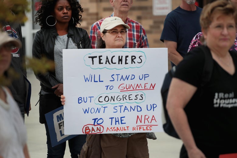 A sign reads, "Teachers will stand up to gunmen but Congress won't stand up to the NRA."