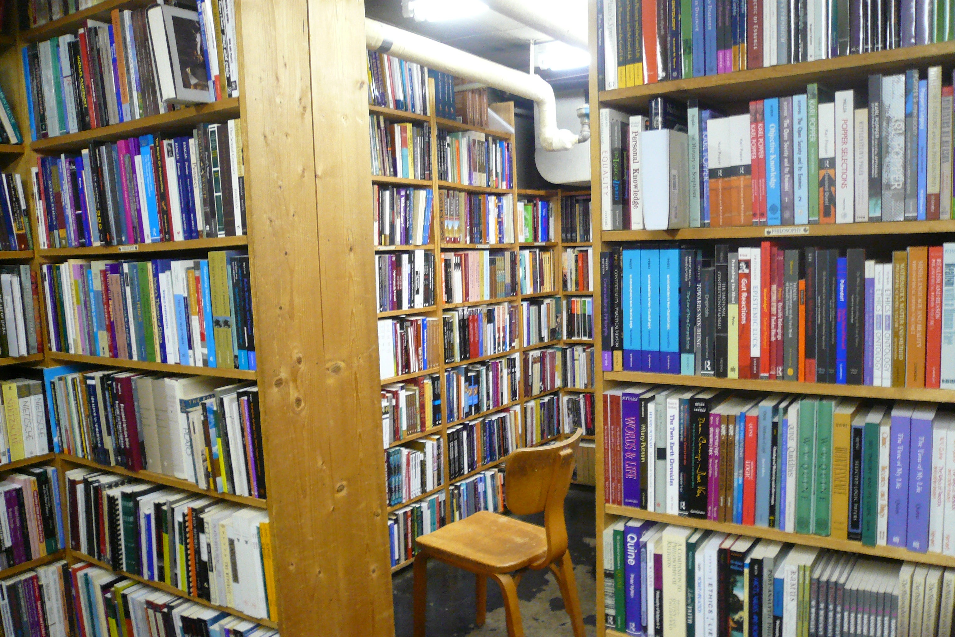 A chair sits in a bookstore's stacks. 