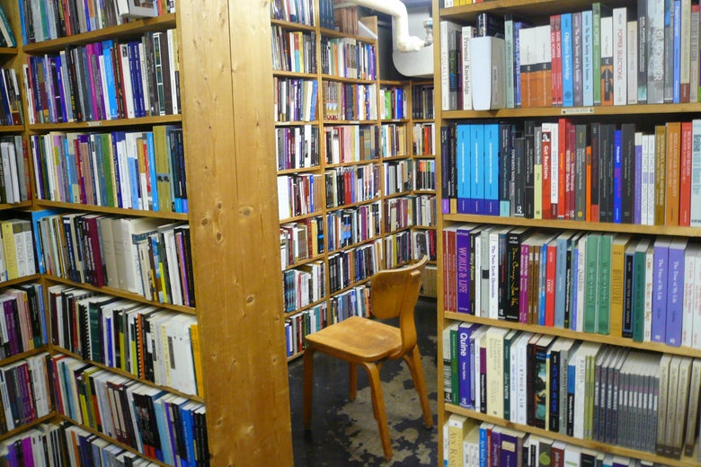 A chair sits in a bookstore's stacks. 