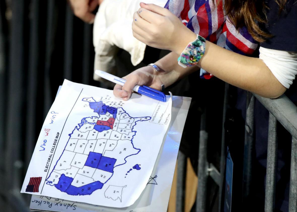 A woman holding a partially filled-in electoral map from the 2016 election.