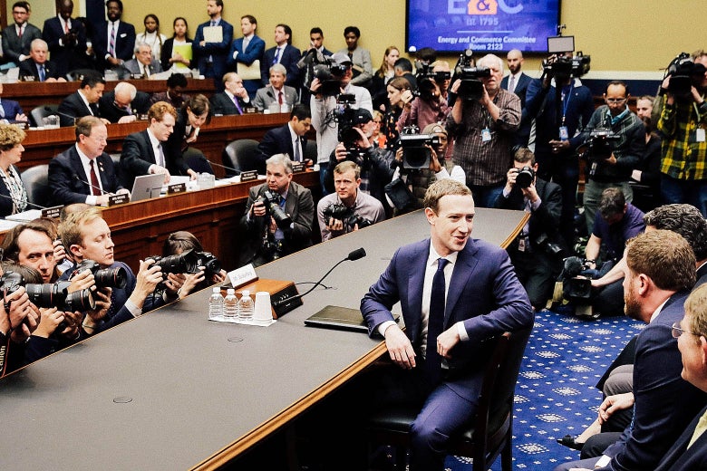 Mark Zuckerberg turns to talk to colleagues at a hearing.