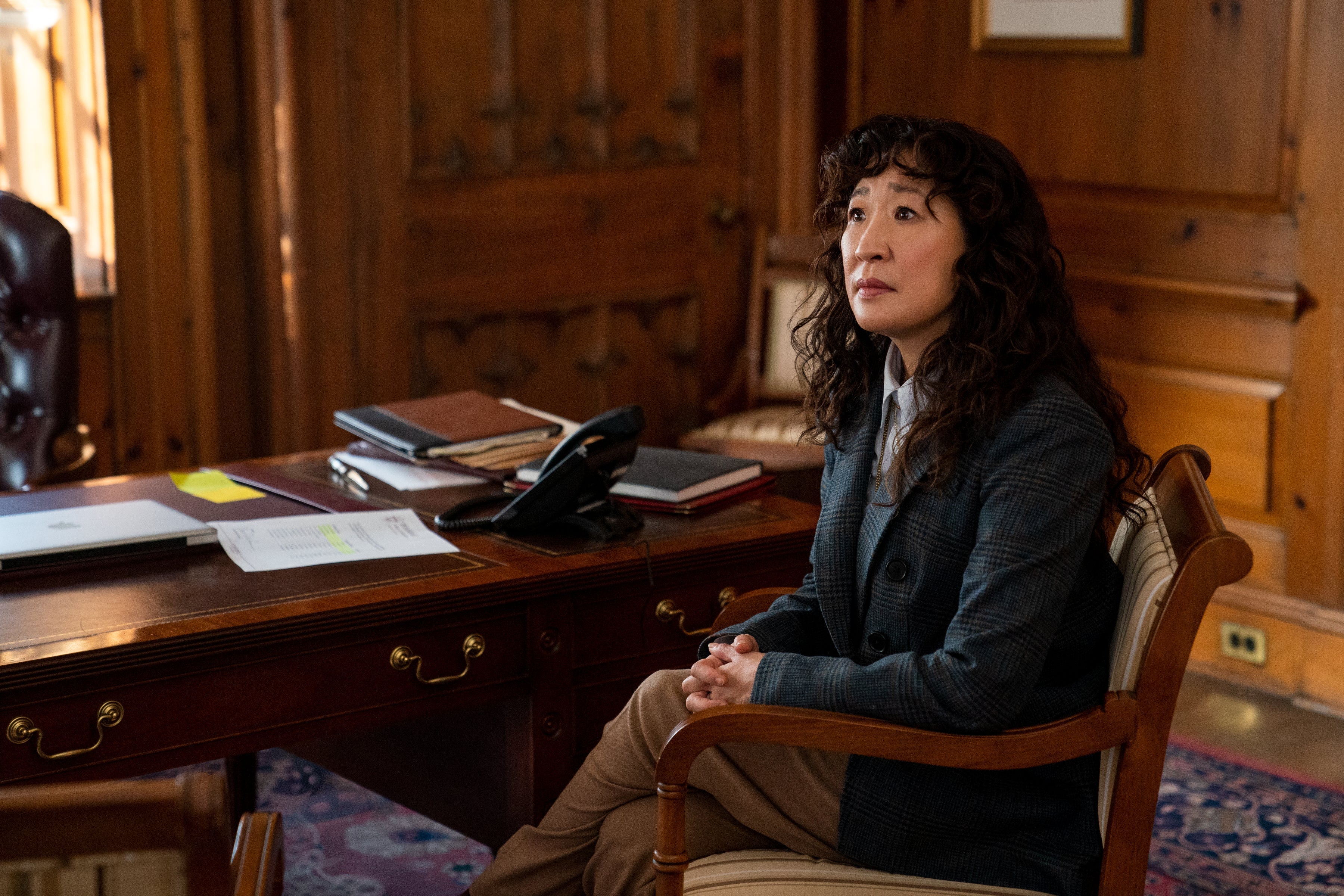 Sandra Oh as Dr. Kim in The Chair, sitting in a chair.
