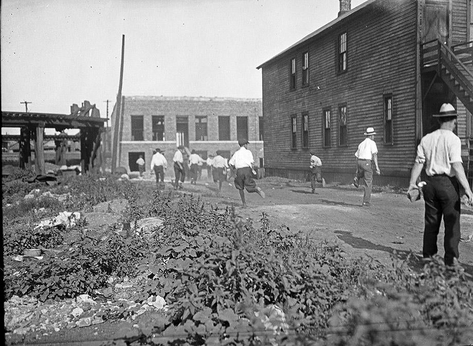 Members of a white mob run with bricks in hand, during the Chicago race riot of July and August, 1919.