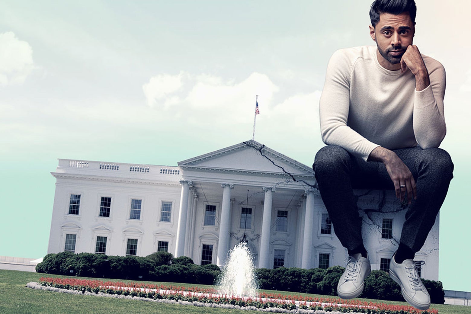 In this photo illustration, Hasan Minhaj sits on one corner of the White House. He's very large, and the White House is very small and seat-size.