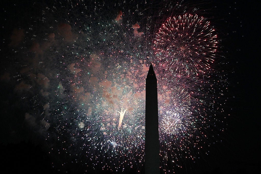 Fireworks explode behind the Washington Monument.
