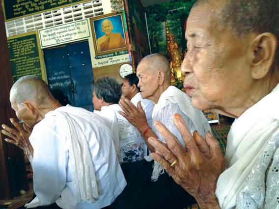 Buddhist nuns praying near a former Khmer Rouge prison and execution ground.