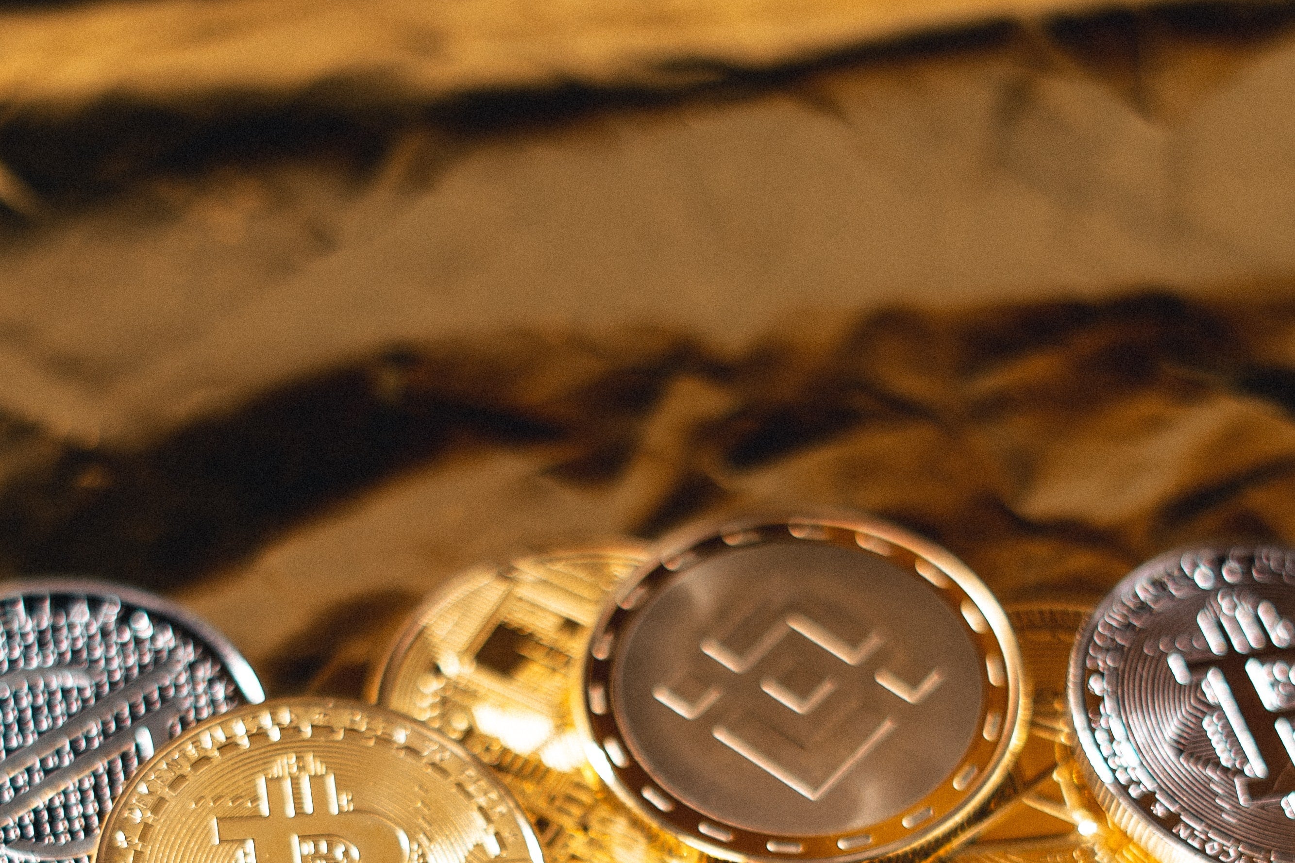 Gold coins with the logos of cryptocurrencies like Bitcoin and Ethereum.