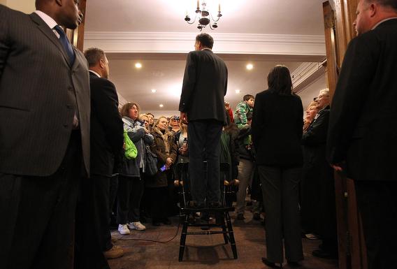 Mitt Romney stands on a chair as he speaks to an overflow crowd during a spaghetti dinner at Tilton School on January 6, 2012 in Tilton, New Hampshire