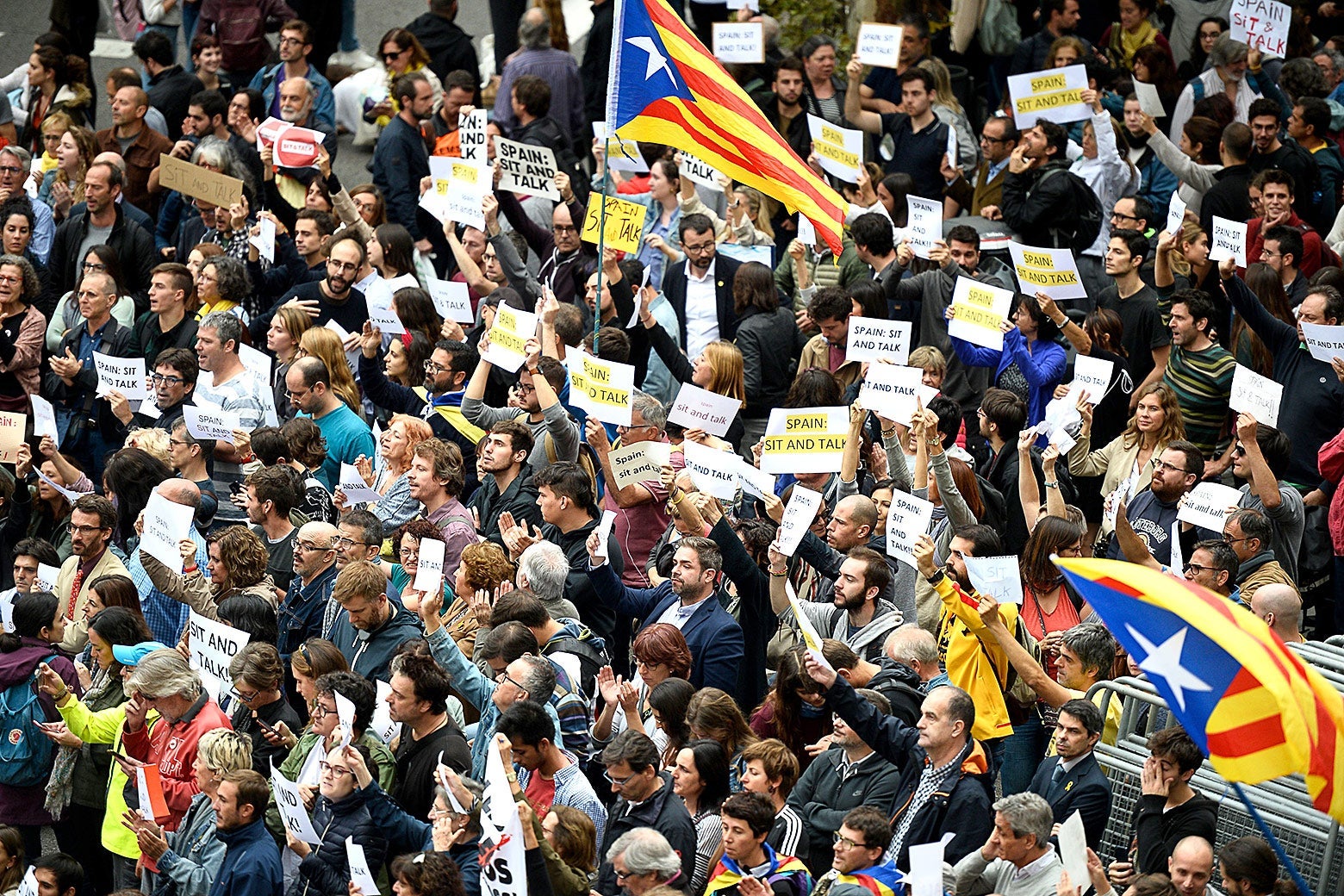 People hold placards reading "Spain: Sit and Talk" on Monday in Barcelona.