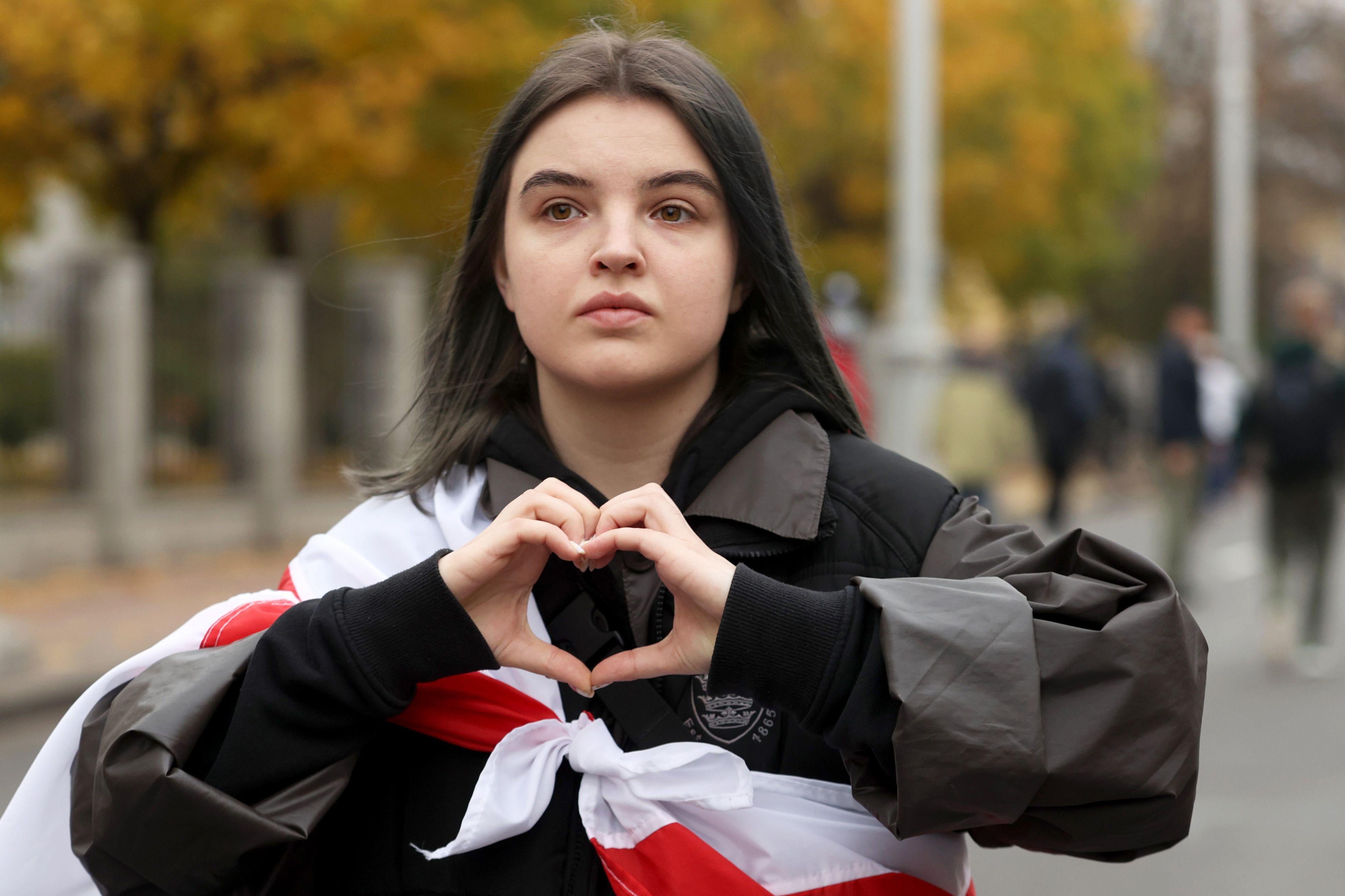 A girl gestures making a heart shape as she takes part in a parade through the streets in Minsk, on October 25, 2020, on the final day of an ultimatum set by the opposition for their embattled strongman leader to resign after months of mass protests. (Photo by Stringer / AFP) (Photo by STRINGER/AFP via Getty Images)