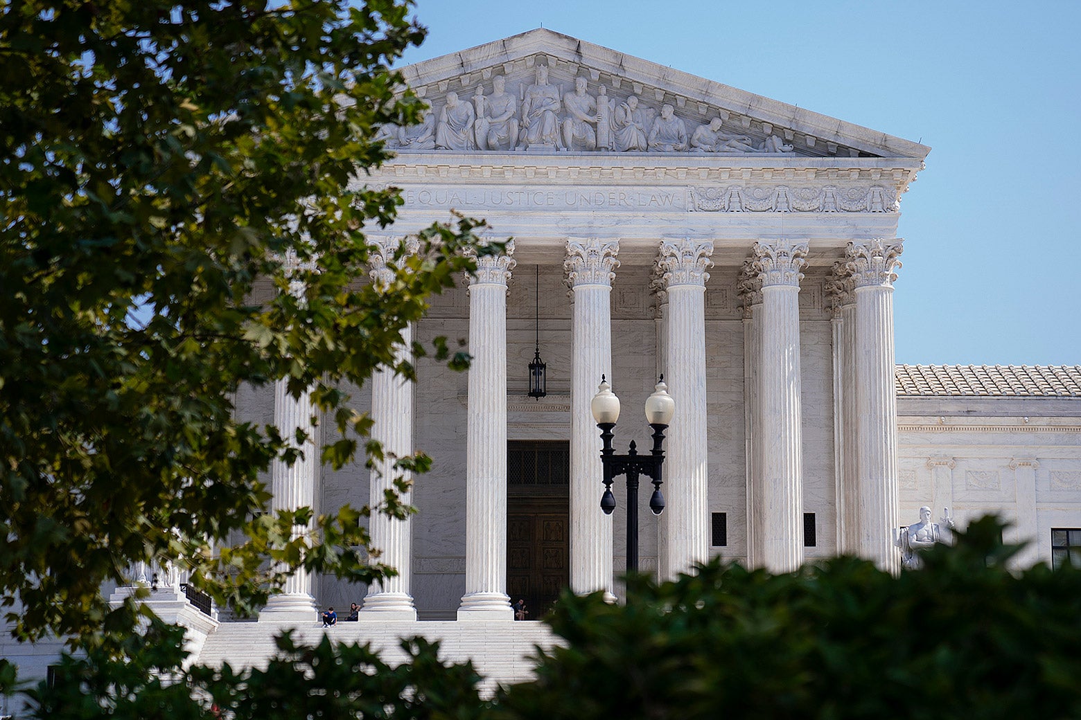 The exterior of the Supreme Court as seen through foliage.
