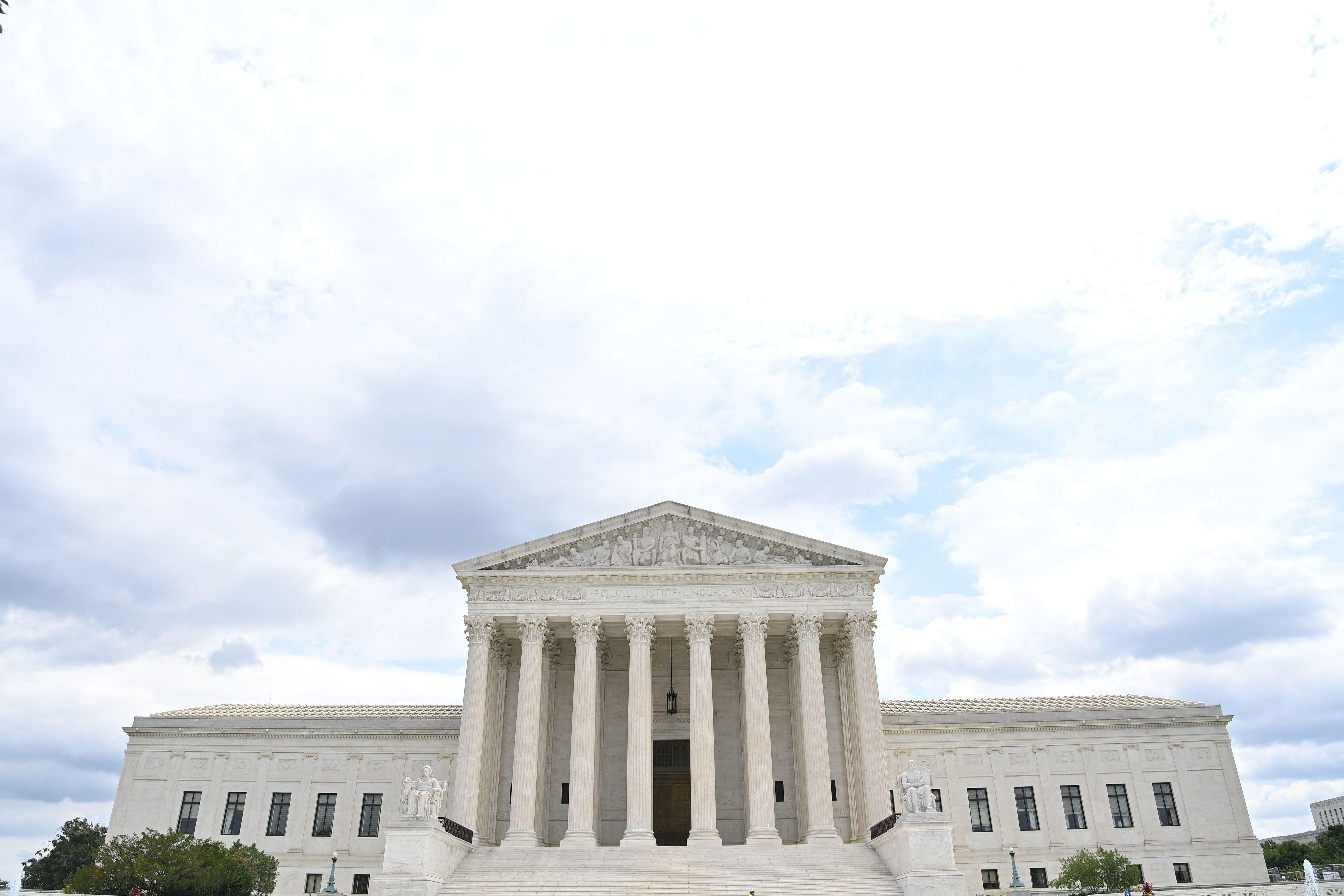 The Supreme Court building and a partly cloudy sky.