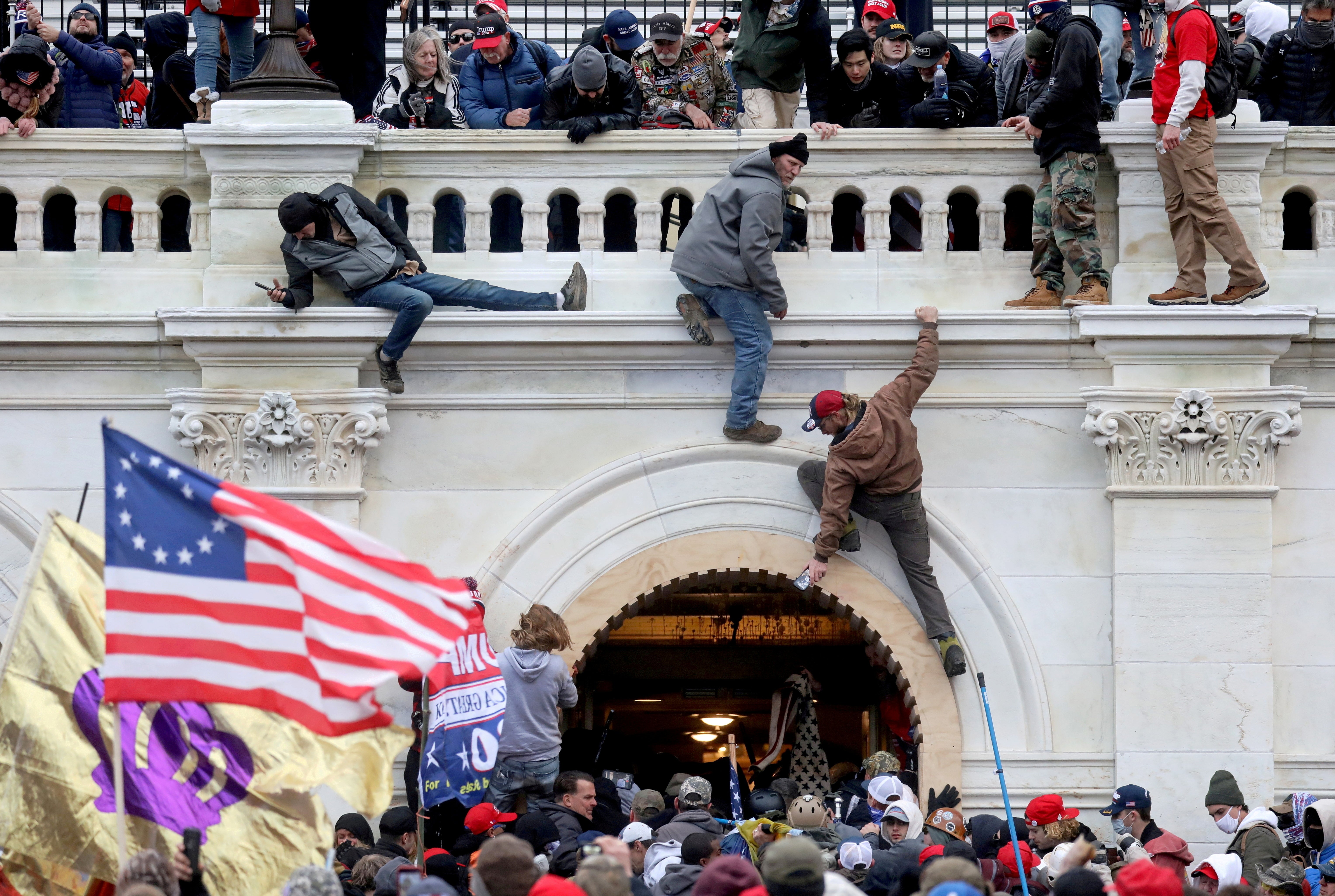A mob of supporters of U.S. President Donald Trump fight with members of law enforcement at a door they broke open as they storm the U.S. Capitol Building on January 6, 2021.