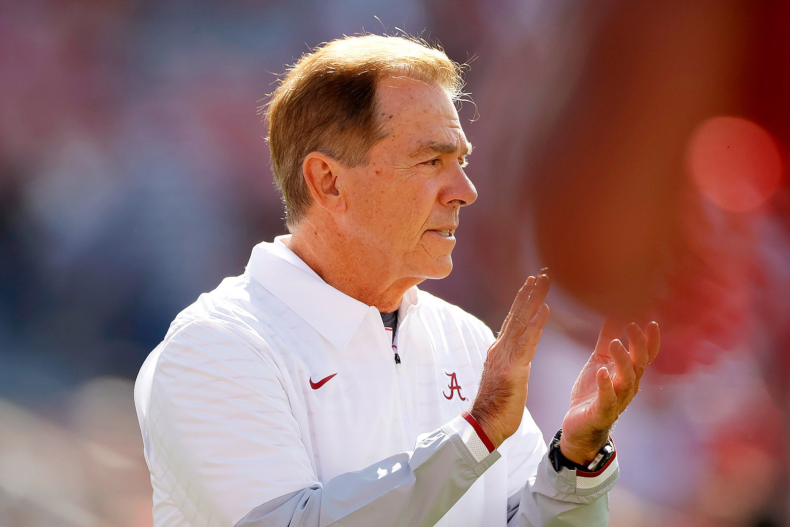 Nick Saban in profile on the sidelines, applauding