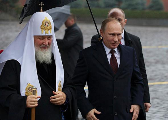 Russian President Vladimir Putin, right, walks with Russian Orthodox Church Patriarch Kirill.