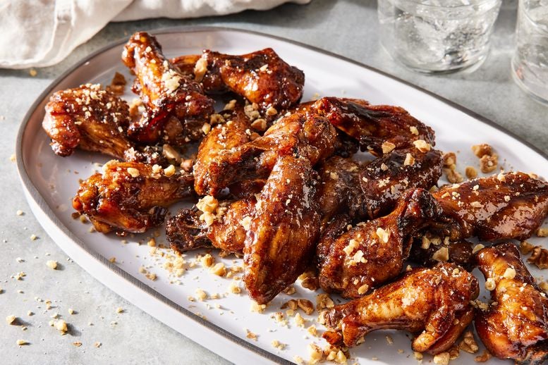 Platter of wings covered in a pomegranate molasses glaze and topped with toasted walnut pieces