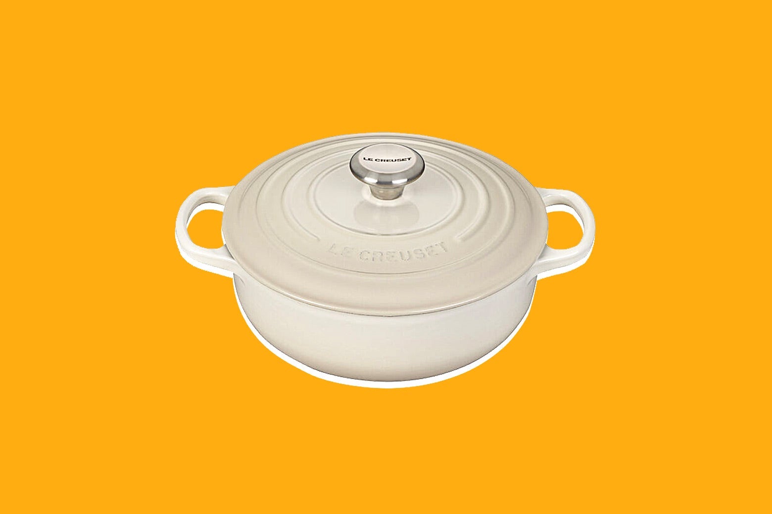 A Le Creuset sauce pot seen against yellow background