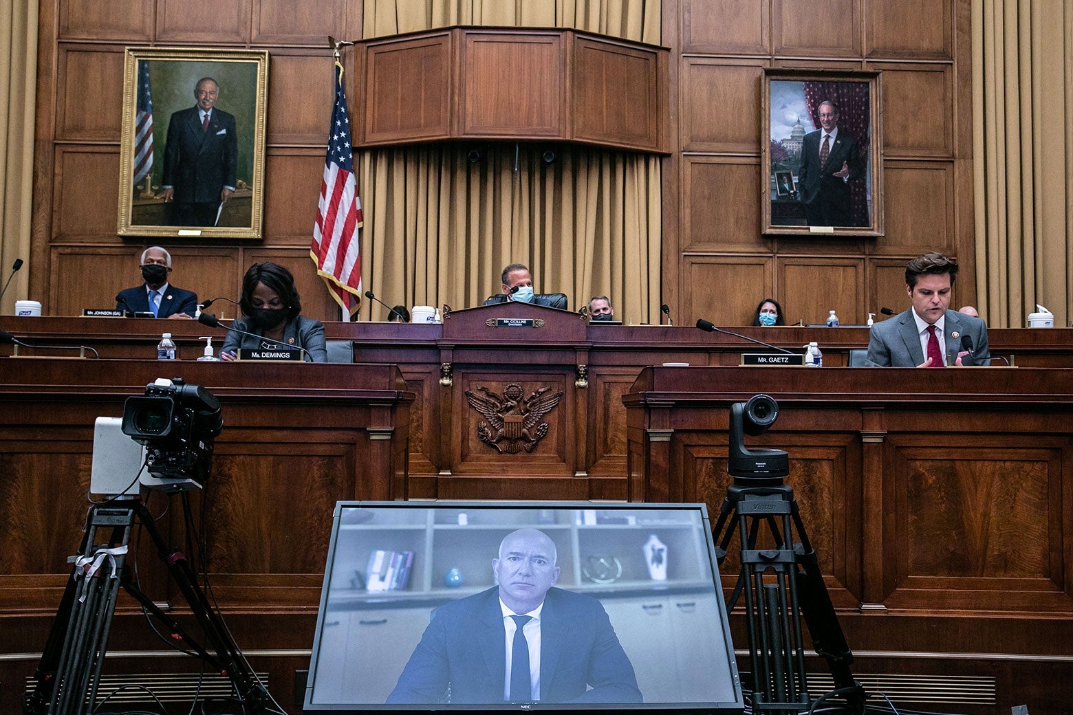 Bezos on a videoconference screen in front of a panel of seated House members in the hearing room