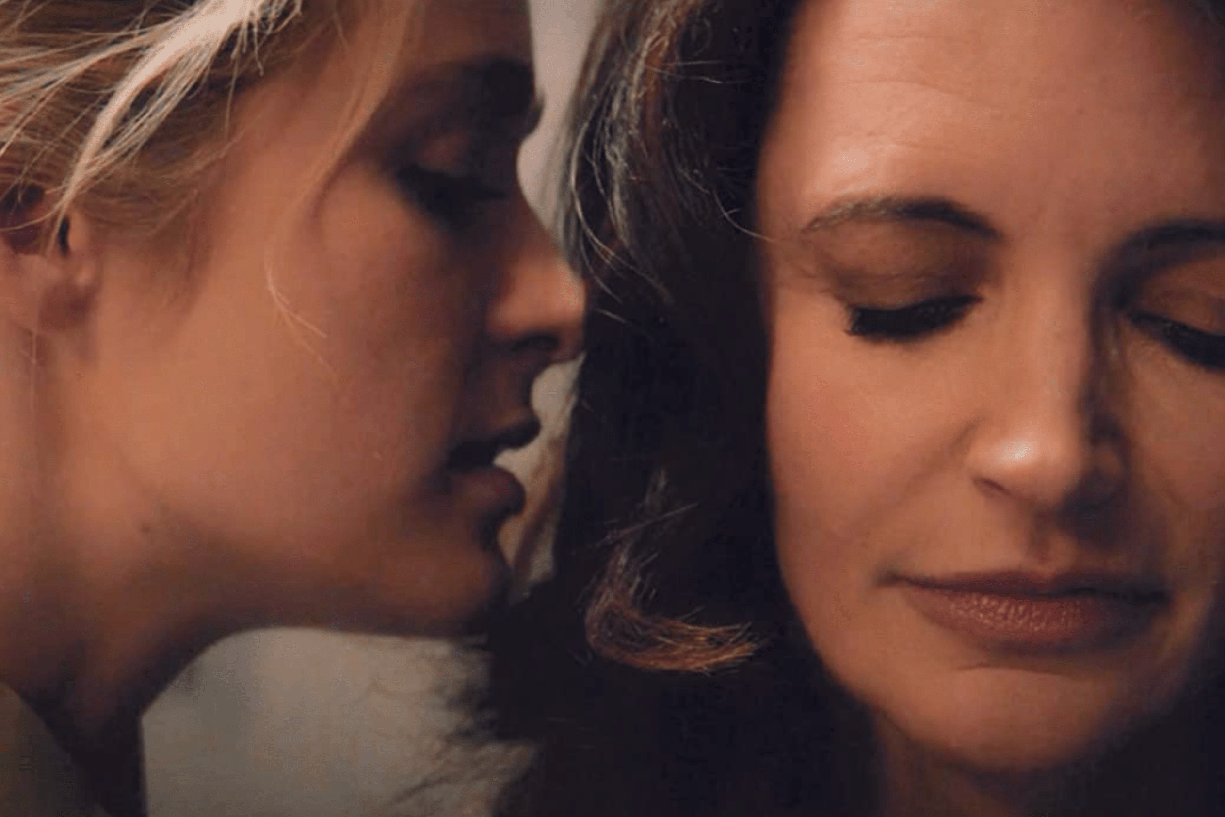 A young woman whispers into the ear of Kristin Davis who you may remember as Charlotte from Sex and the City. 