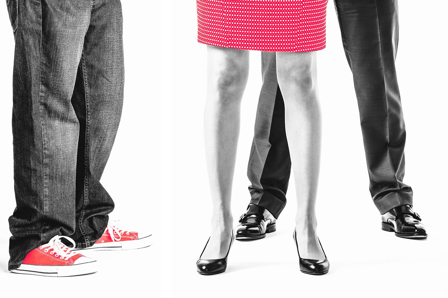 A woman in a business suit standing between a man also in a suit and a man in jeans and sneakers.