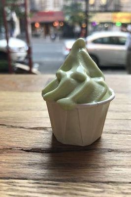 A small cup of pickle soft serve ice cream. 