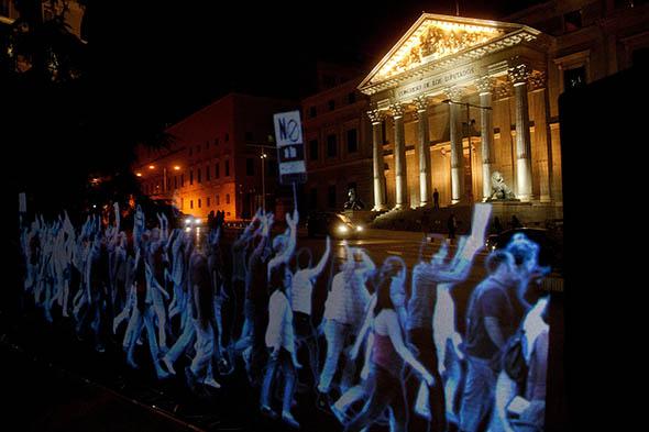 Holographic images representing a protest are projected in front