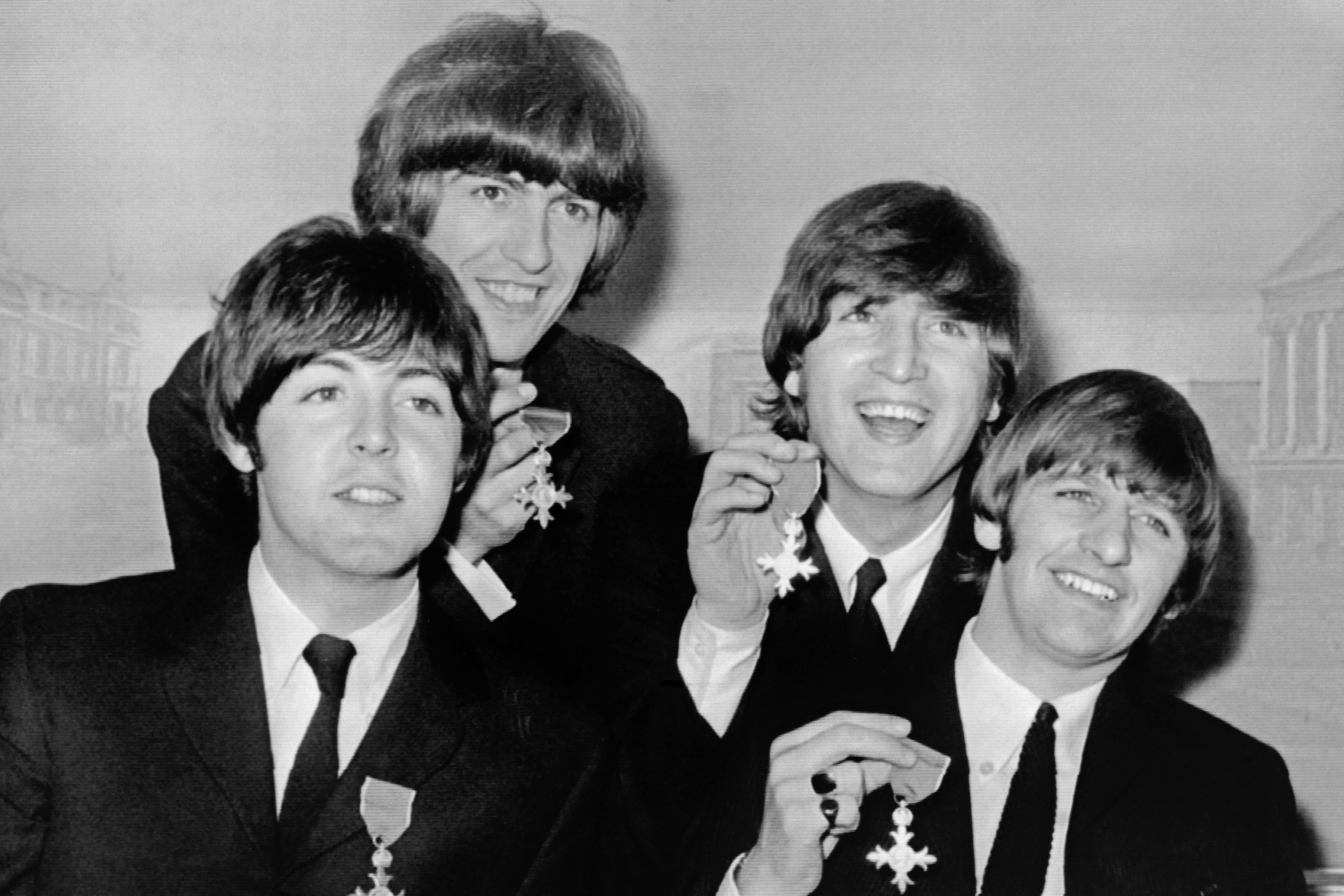 The Beatles showing off their British Empire Medals.