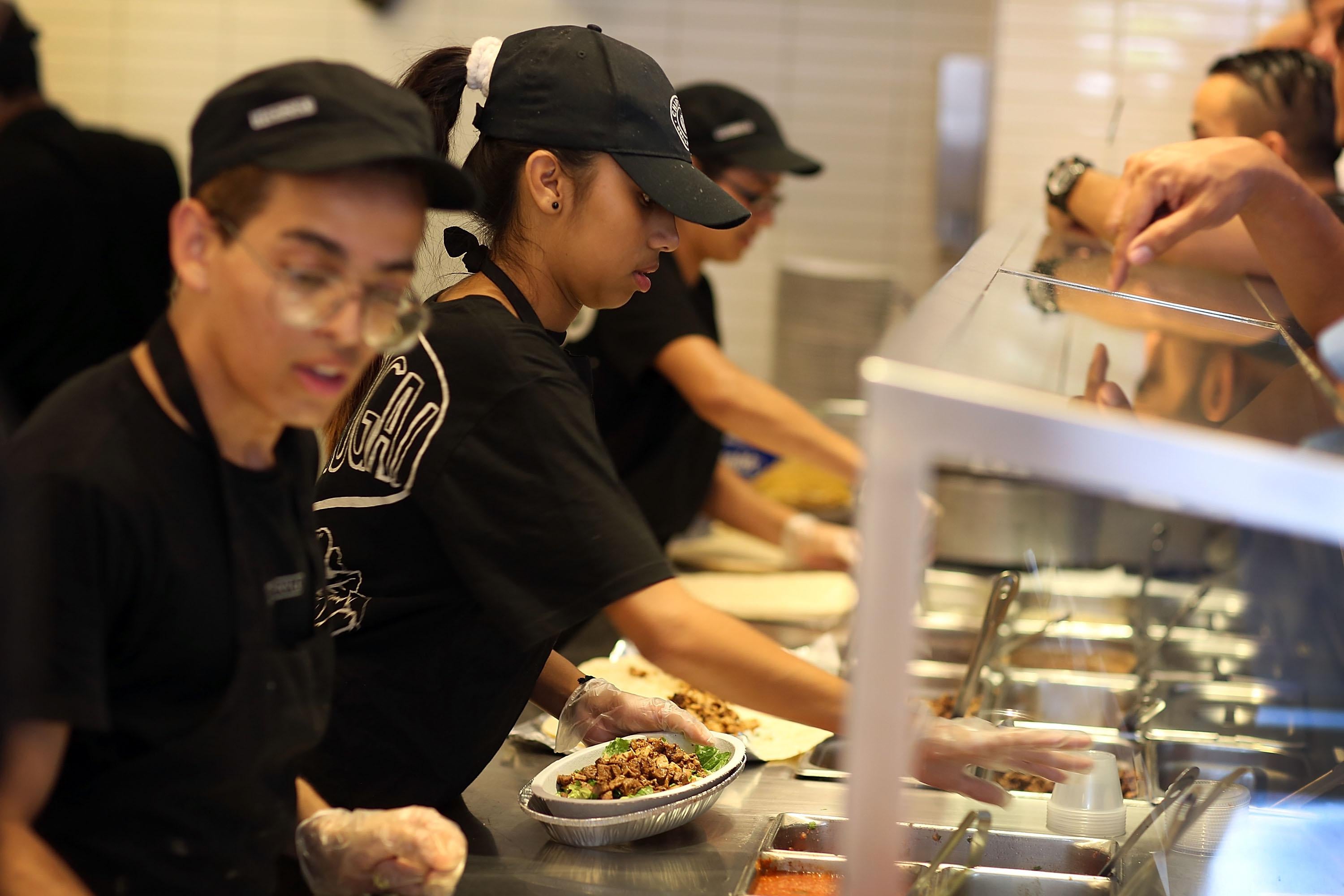 Chipotle restaurant workers fill orders for customers in 2015 in Miami.