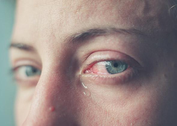 Exhausted woman with bloodshot eyes, crying
