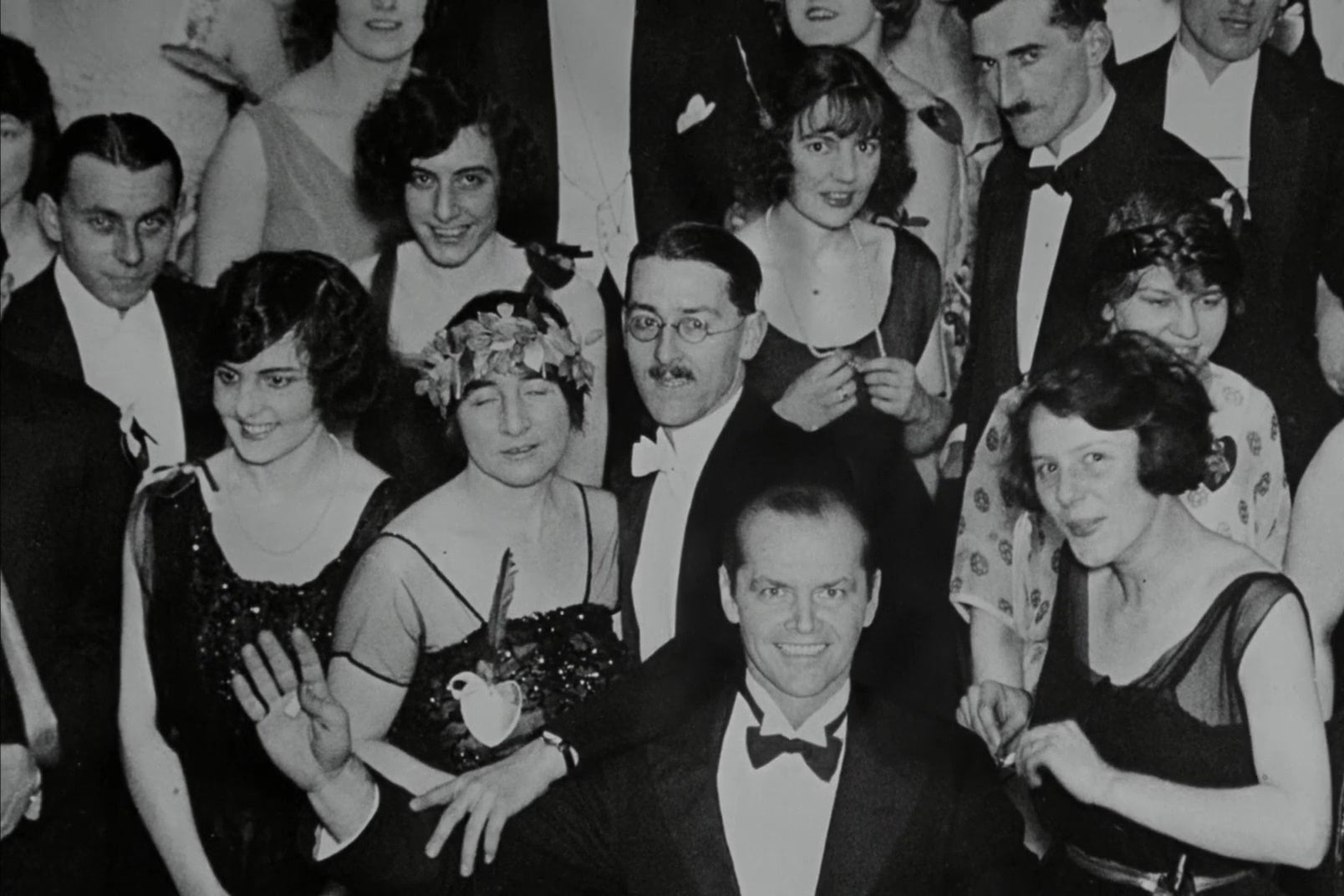 In a doctored photo from The Shining, Jack Nicholson waves from the front of a crowd attending a formal party.