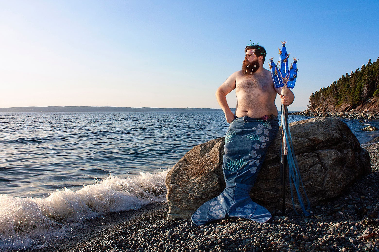 A hairy, colorful merman poses on the Canadian cost. 