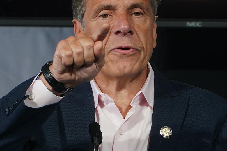 Andrew Cuomo at the Tribeca Festival, speaking on stage and pointing his finger outward.