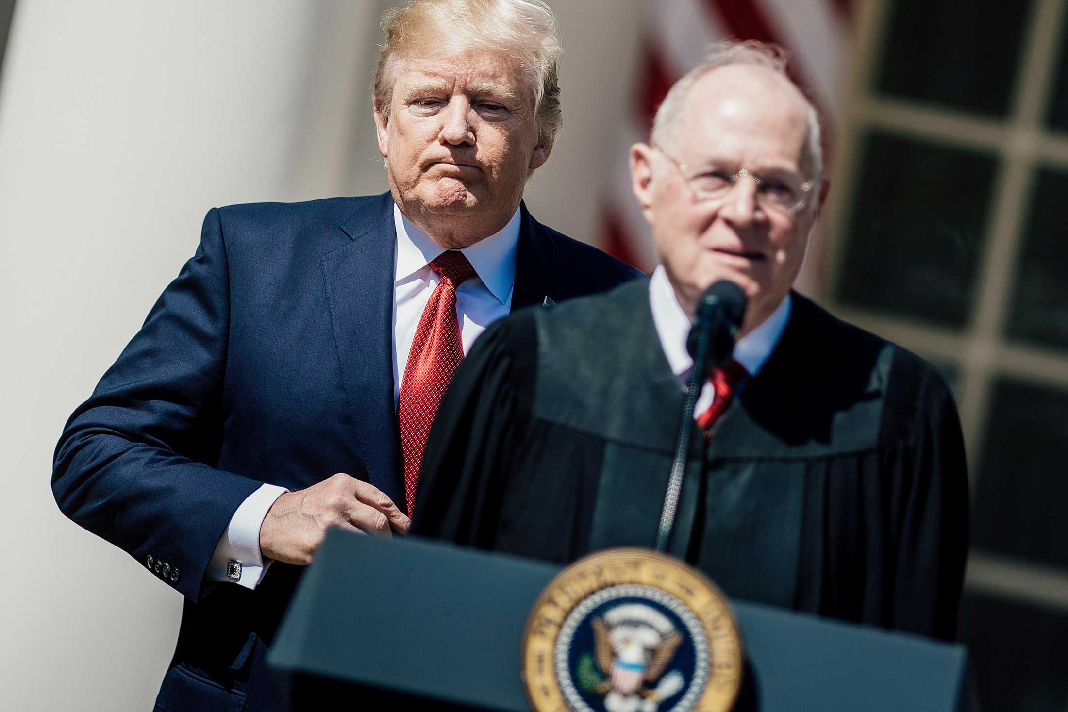 President Donald Trump listens while Supreme Court Justice Anthony Kennedy speaks during a ceremony at the White House on April 10, 2017.