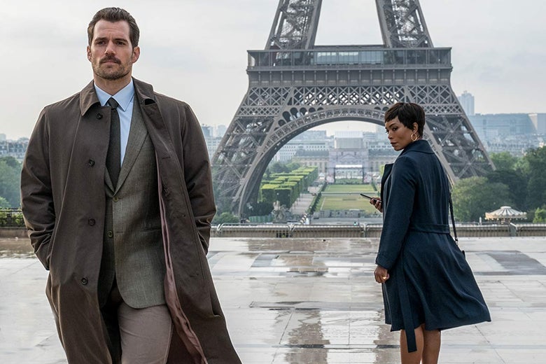 Angela Bassett stares after Henry Cavill, who walks toward the camera. The bottom of the Eiffel Tower is in the background.