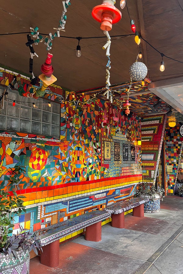 Bright side wall that features mosaic-like tile and benches.