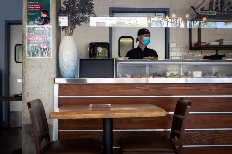 Sushi chef wearing mask in empty restaurant