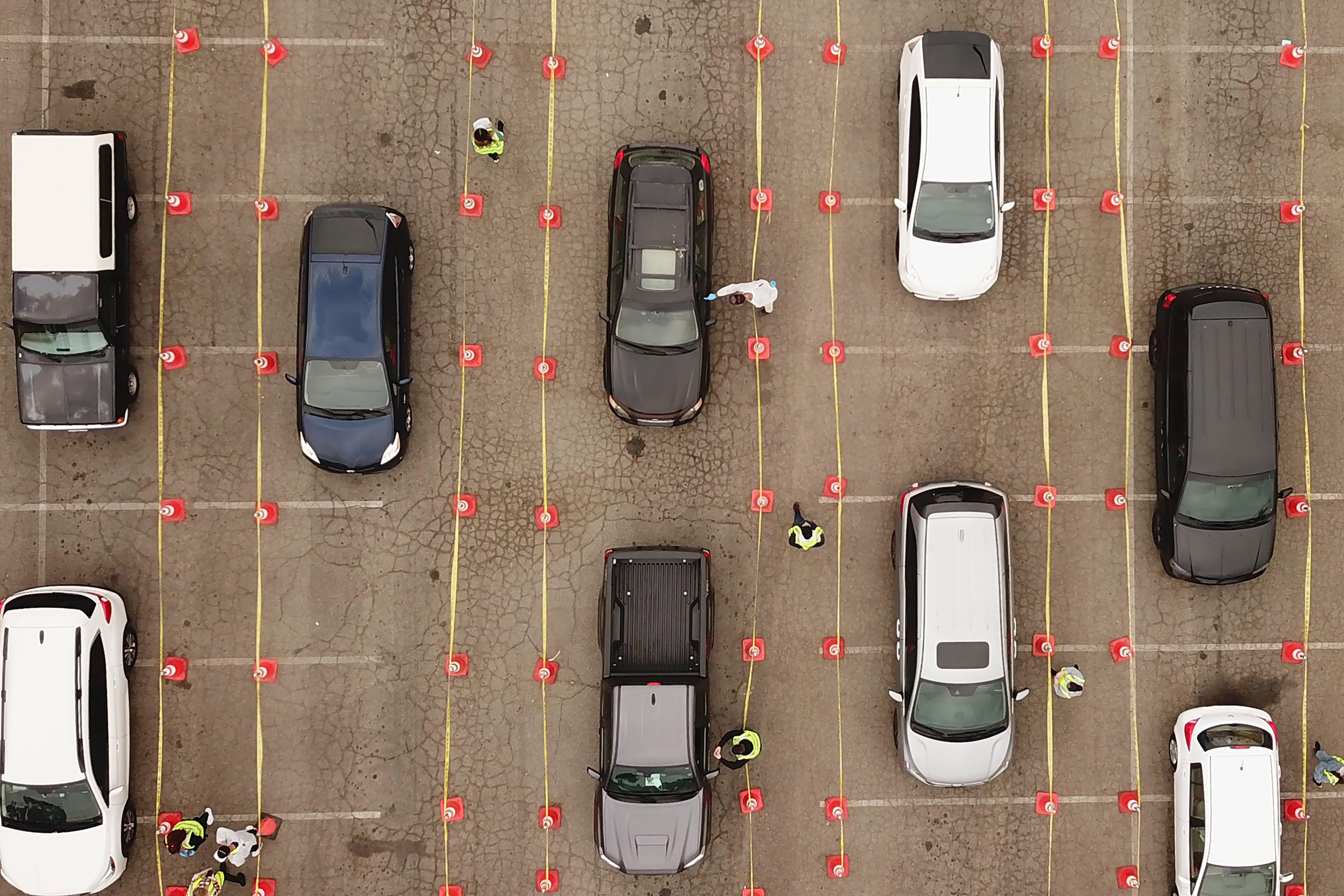 An aerial view of 9 cars waiting in line at a COVID-19 testing site.