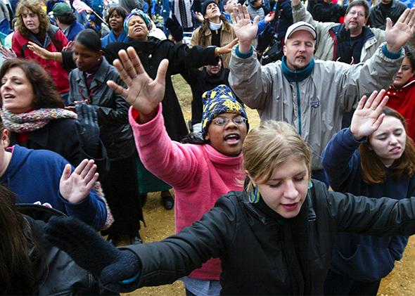 Worshipers raise their hands as they pray during the America for Jesus rally on Oct. 22, 2004, in Washington, D.C.