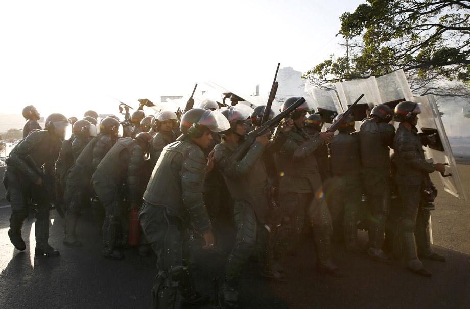 Riot police shoot tear gas as they fight against students during a protest against President Nicolas Maduro's government in Caracas February 16, 2014.