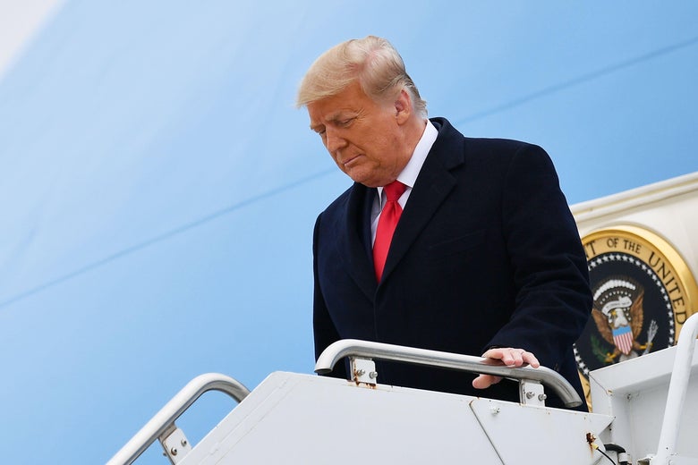 Trump steps off Air Force One with his head slightly bowed