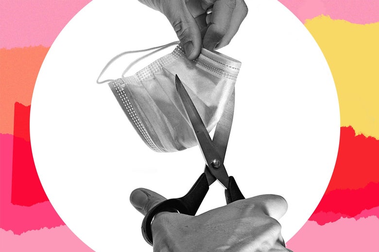 A surgical mask being cut with a pair of scissors.