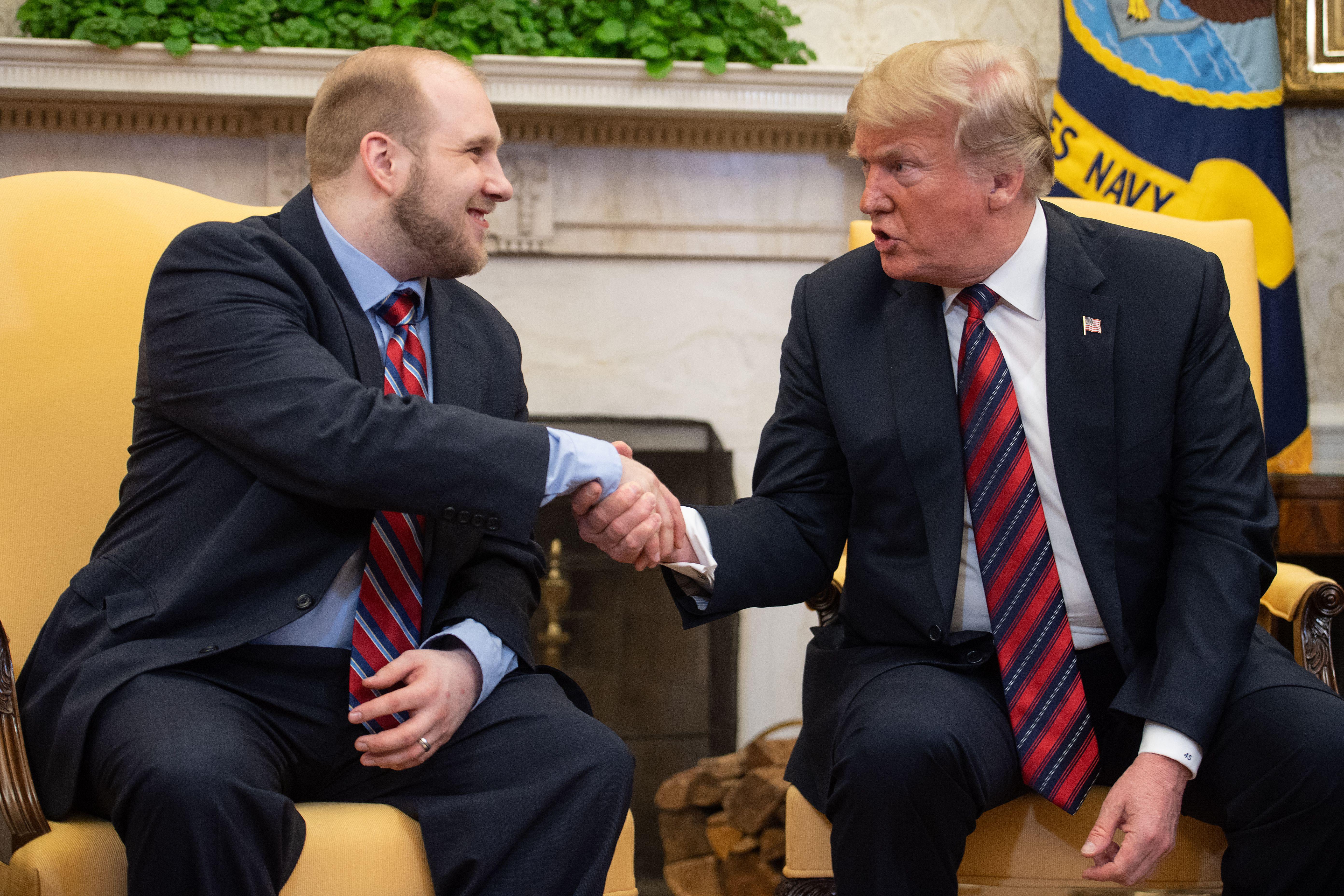 President Donald Trump shakes hands with Joshua Holt, who had been detained in Venezuela for two years, in the Oval Office at the White House in Washington, DC, on May 26, 2018. 