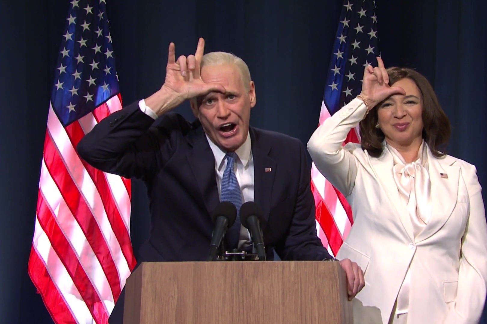 Jim Carrey as Joe Biden and Maya Rudolph as Kamala Harris both put their hands to their foreheads in the shape of an "L" in a still from SNL.