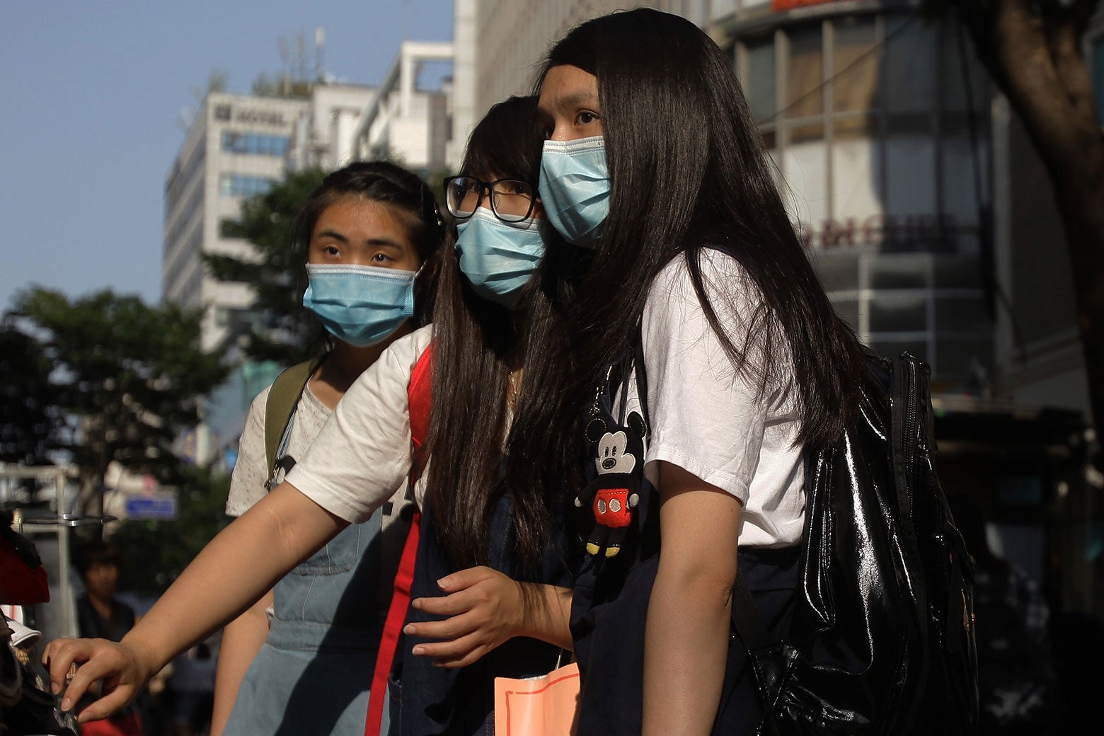 Three women wearing protective masks