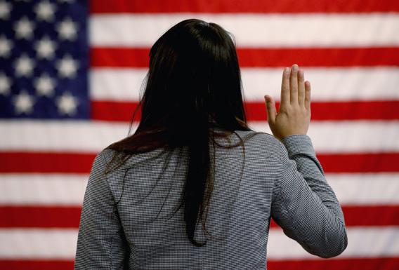 An woman takes the oath of allegiance during a naturalization ceremony at the at district office of the U.S. Citizenship and Immigration Services (USCIS) on January 28, 2013 in Newark, New Jersey.