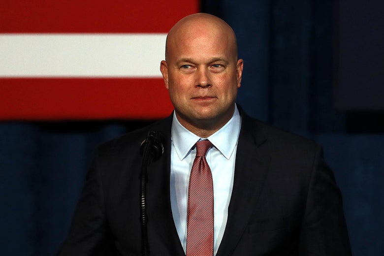 Whitaker squints slightly as he stands in front of a podium.