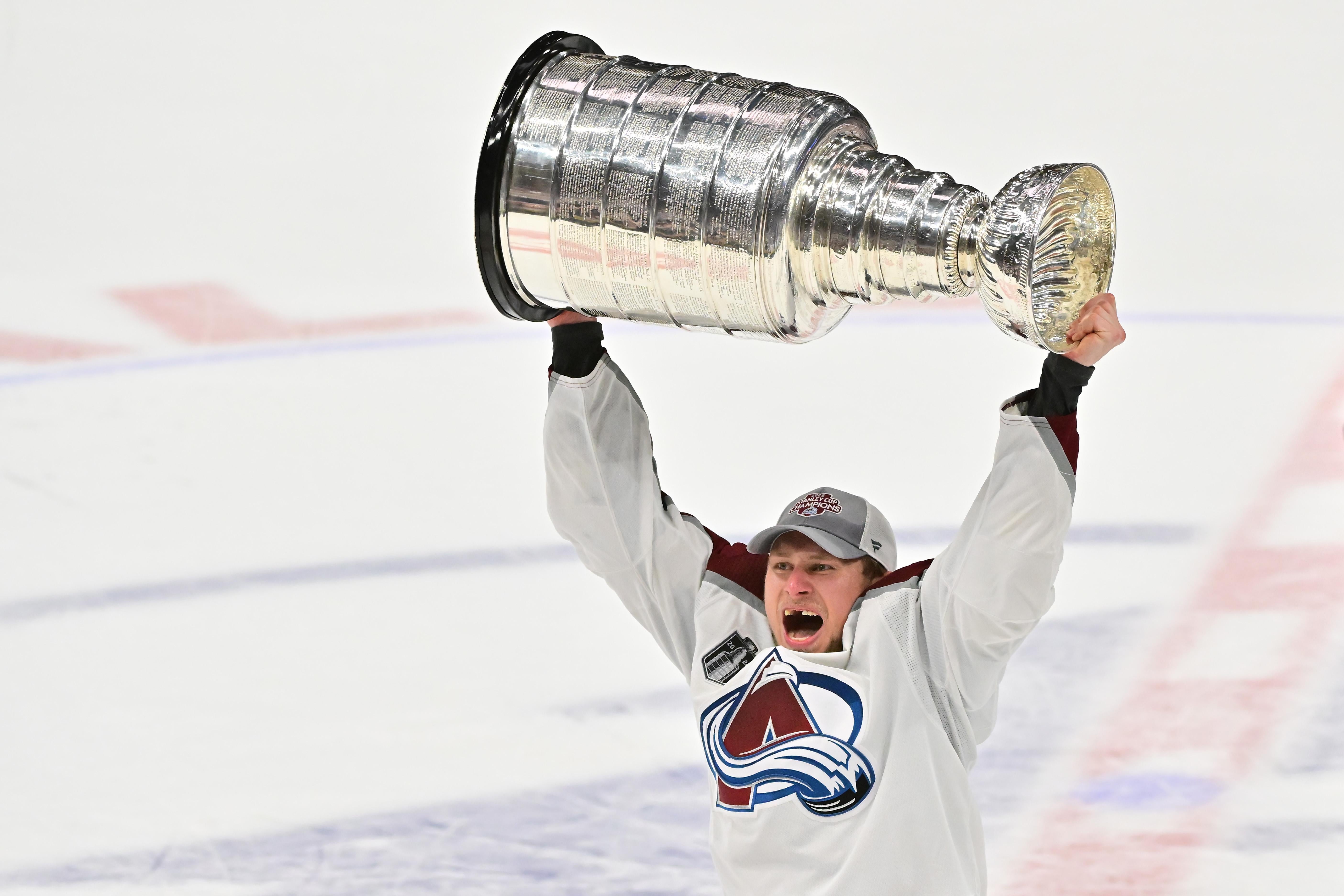 Johnson, missing several front teeth, screams in celebration and hoists the Cup above his head.